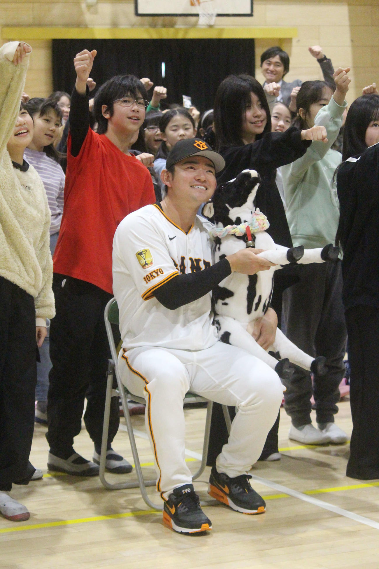 学校のマスコットキャラクター「メリー」を抱えて記念撮影する巨人萩尾匡也