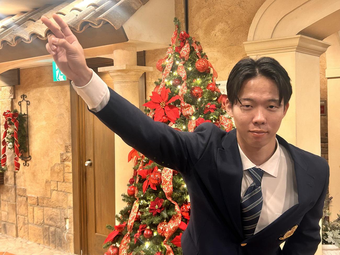 クリスマスツリーを背に投球ポーズをする日本ハム1位明大・大川慈英投手（撮影・平山連）