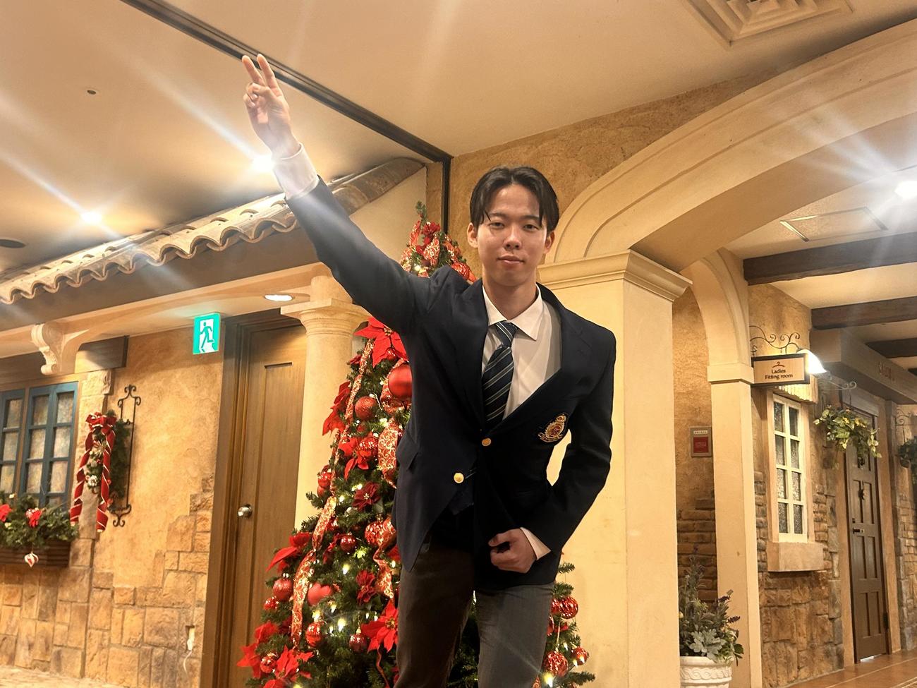クリスマスツリーを背に投球ポーズをする日本ハム1位明大・大川慈英投手（撮影・平山連）