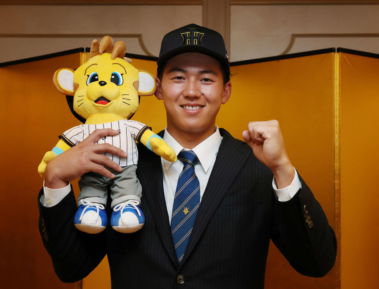 仮契約を終えコラッキーを手にガッツポーズをする阪神ドラフト1位の創価大・立石（撮影・増田悦実）