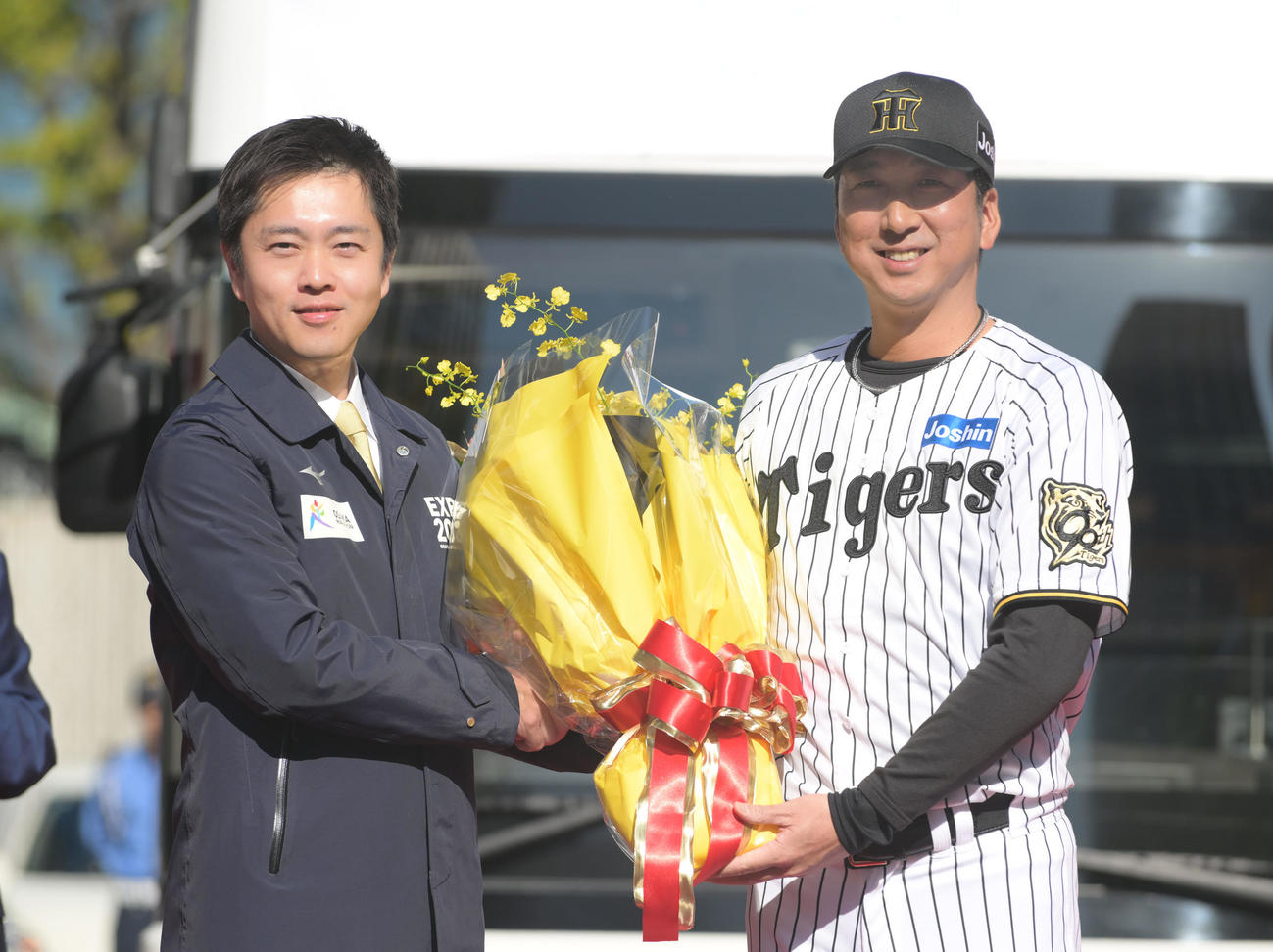 阪神タイガース優勝記念パレードのオープニングセレモニーで吉村大阪府知事（左）から花束を贈呈される藤川監督（撮影・滝沢美穂子）