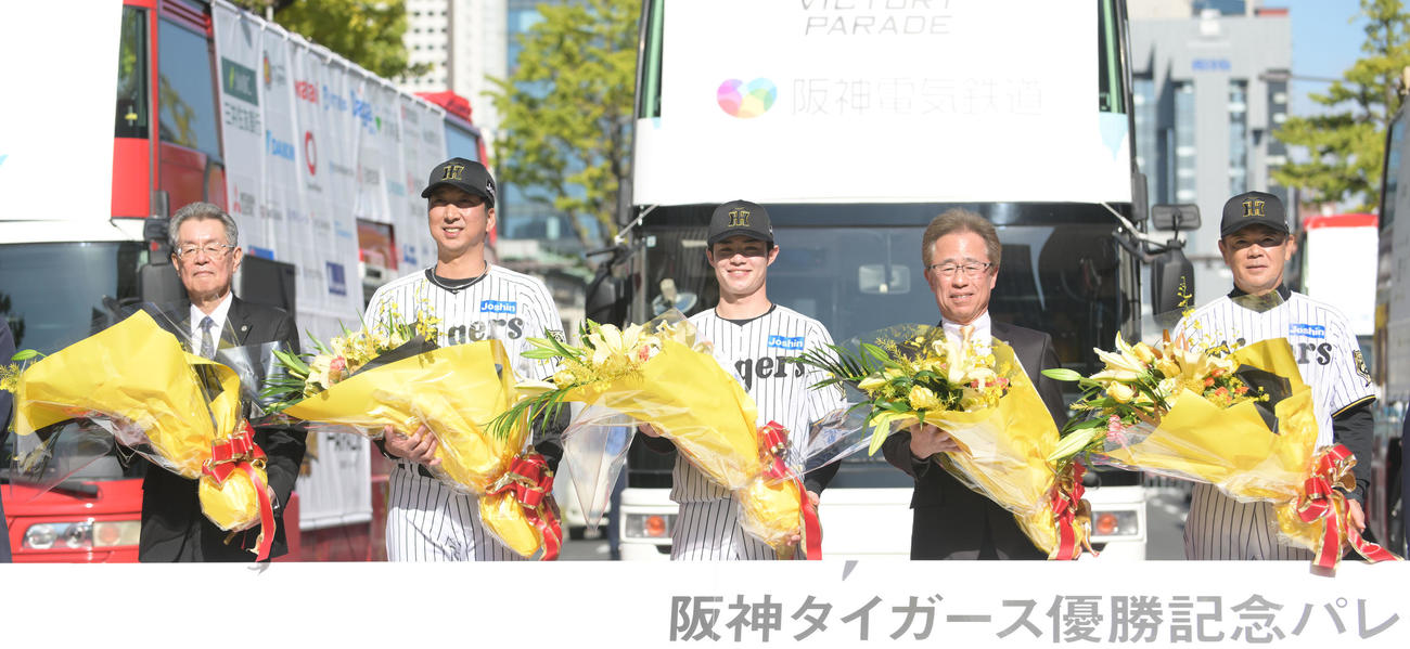 阪神タイガース優勝記念パレードのオープニングセレモニーで記念撮影をする左から秦球団オーナー、藤川監督、中野選手会長、粟井球団社長、和田次期ヘッドコーチ（撮影・滝沢美穂子）