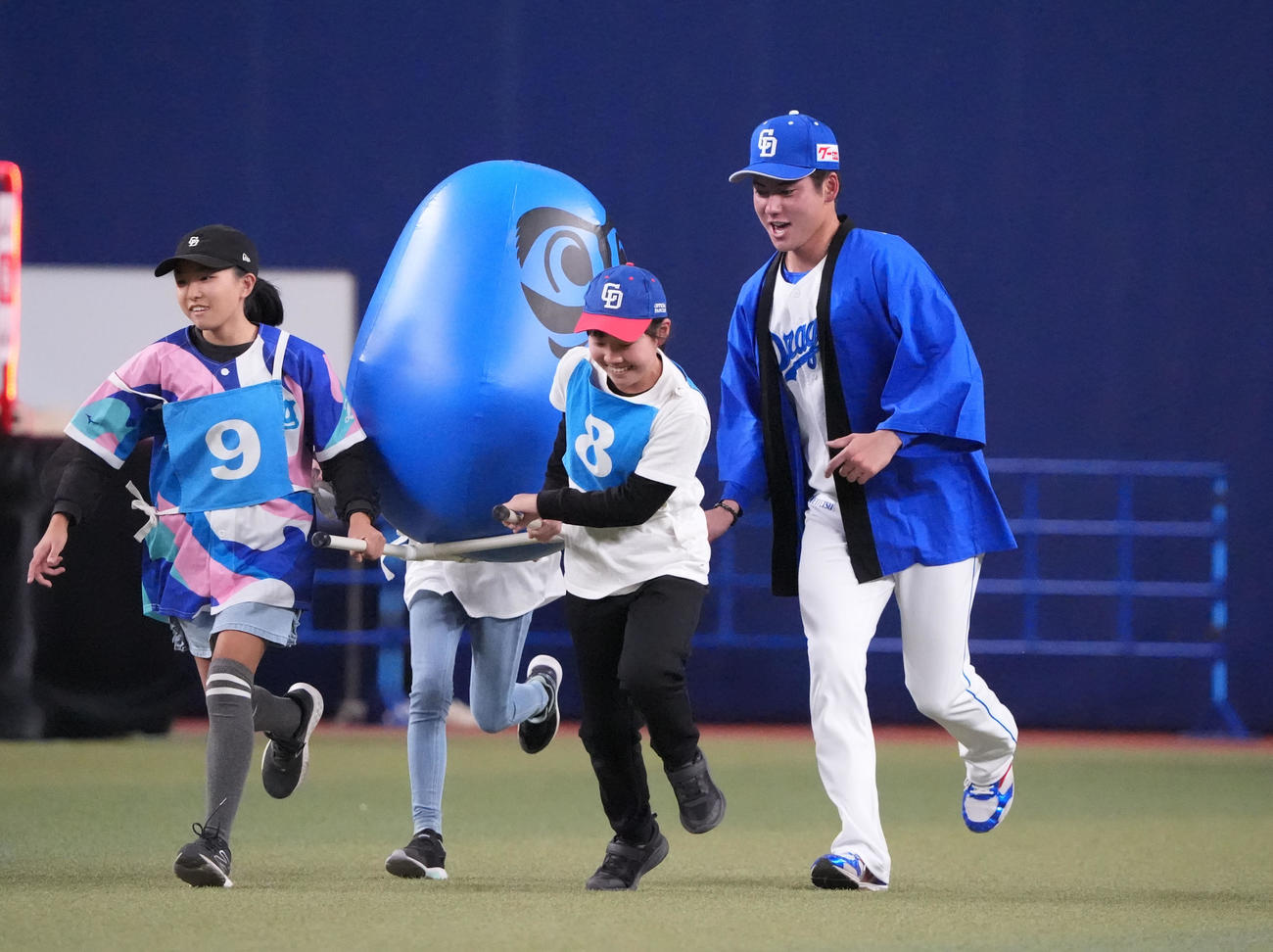 金丸（右）はファンとだるま運びレースをする（撮影・森本幸一）