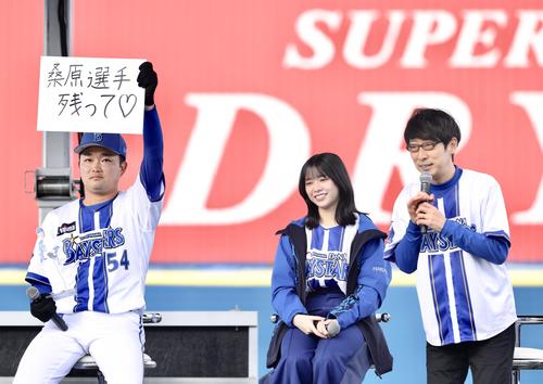 「桑原選手残って」と記されたフリップを掲げるDeNA石田裕(左)。右はダーリンハニー吉川正洋、中央は日向坂46山口陽世(撮影・河田真司)