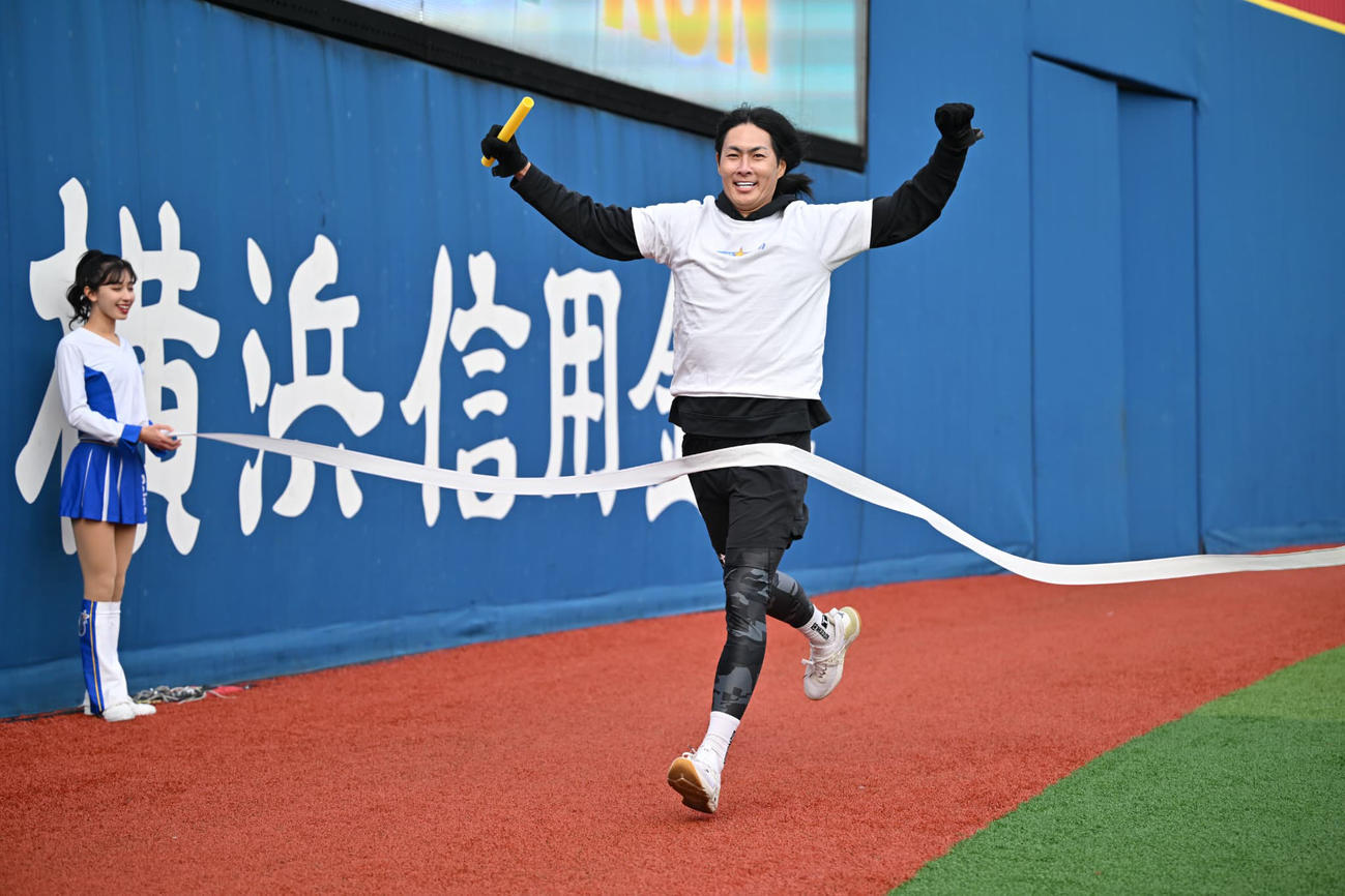 リレー対決でゴールに飛び込む石川雄洋氏（球団提供）