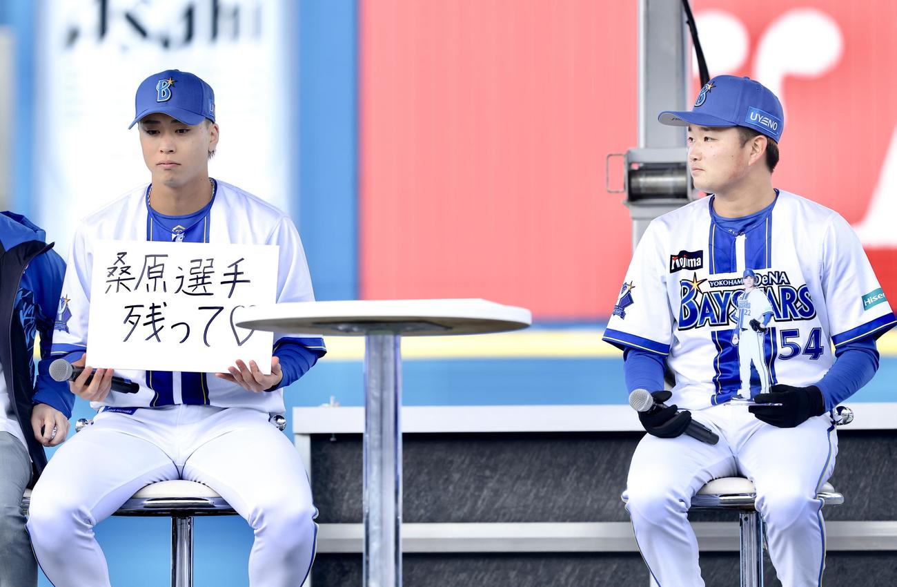 「桑原選手残って」と記されたフリップを手にするDeNA入江大生（左）と石田裕（撮影・河田真司）