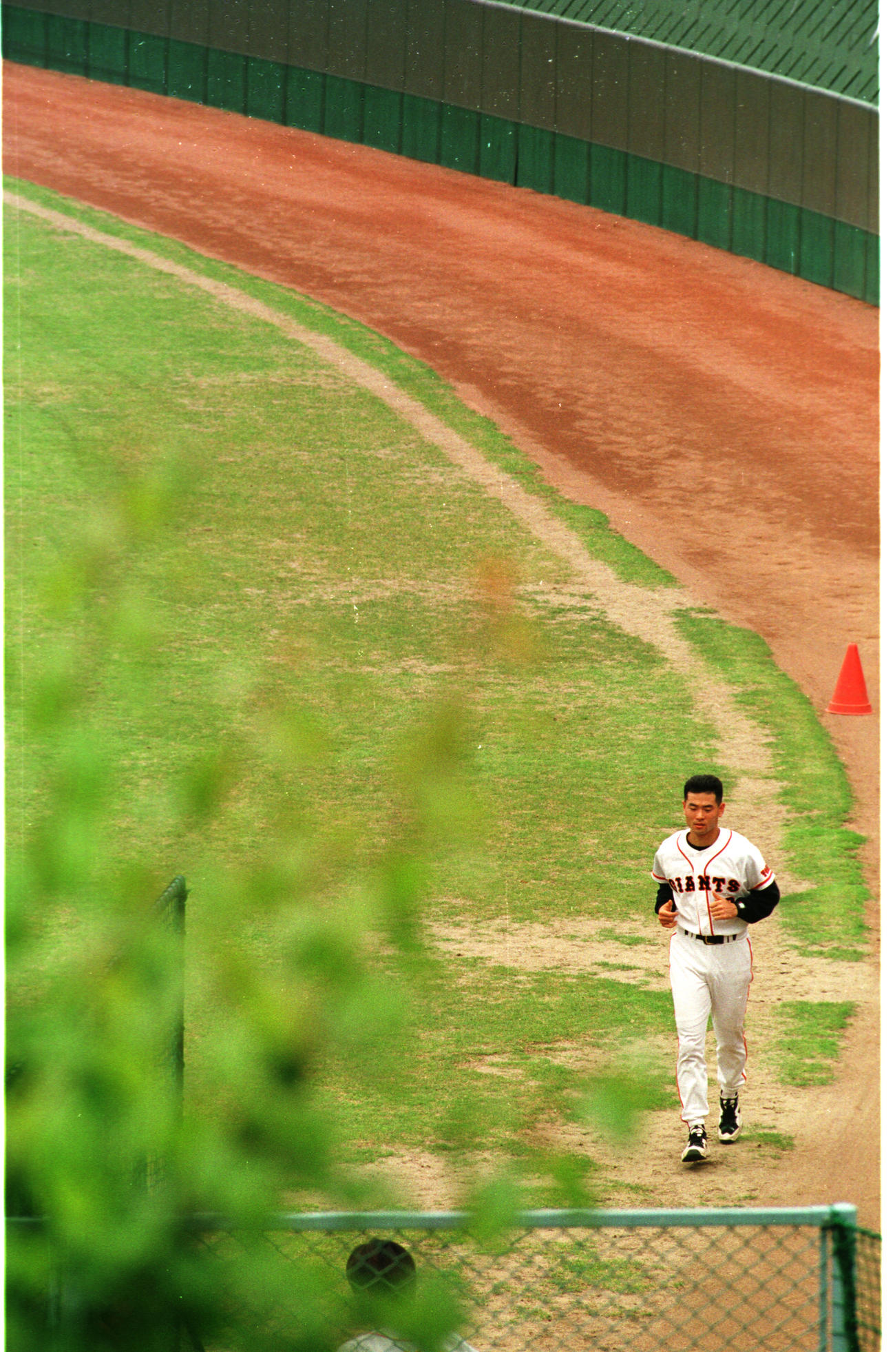 右ひじ手術後のリハビリを兼ねて外野フェンス際をランニングする桑田真澄(1996年6月撮影)