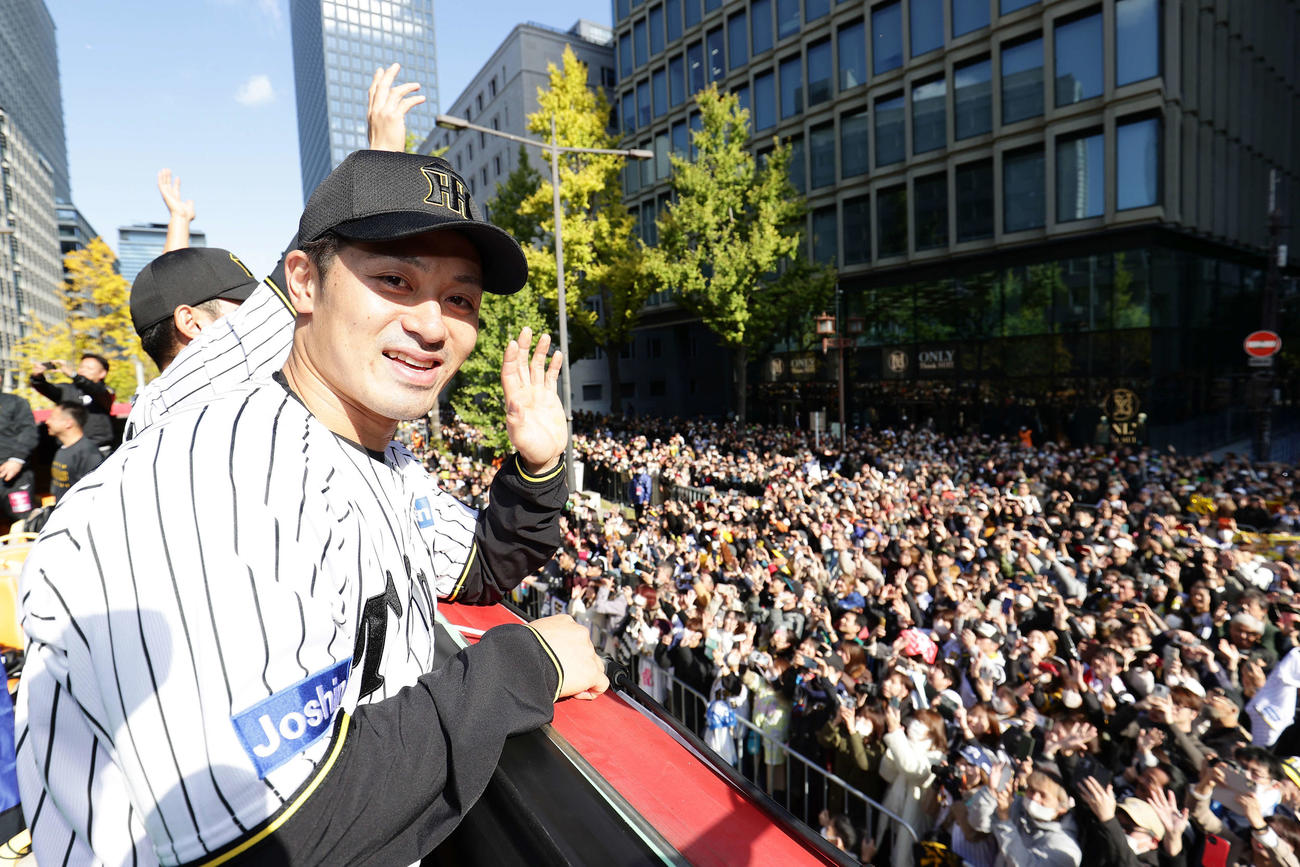 優勝パレードで沿道のファンに手を振る阪神坂本誠志郎（撮影・前田充）
