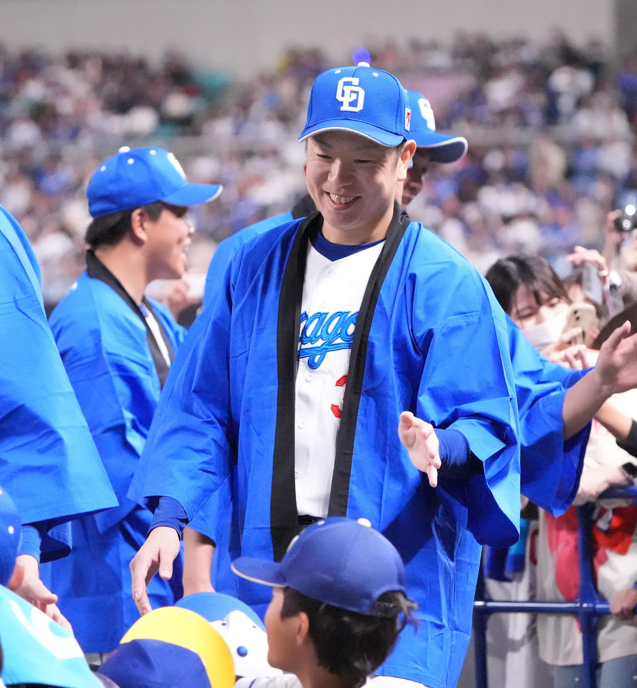松葉（奥）はファンとタッチを交わし入場する（撮影・森本幸一）