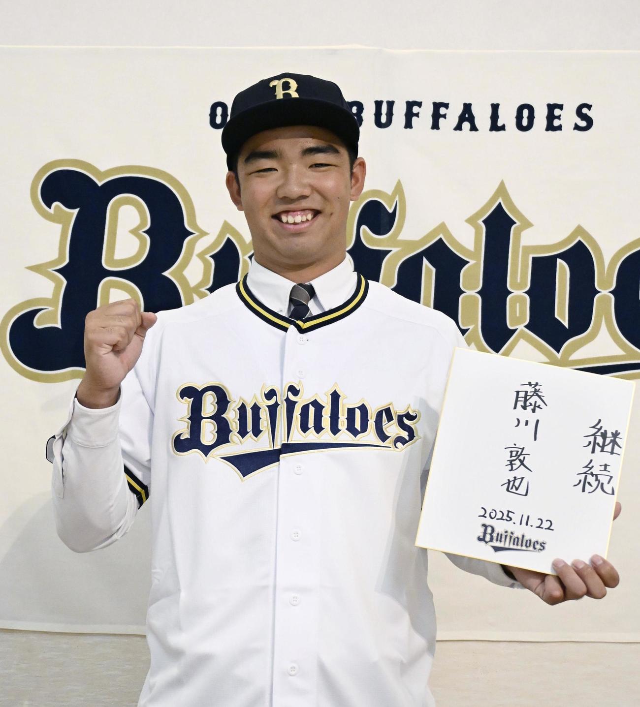オリックスへの入団が決まり、色紙を手にガッツポーズする延岡学園高の藤川敦也（共同）