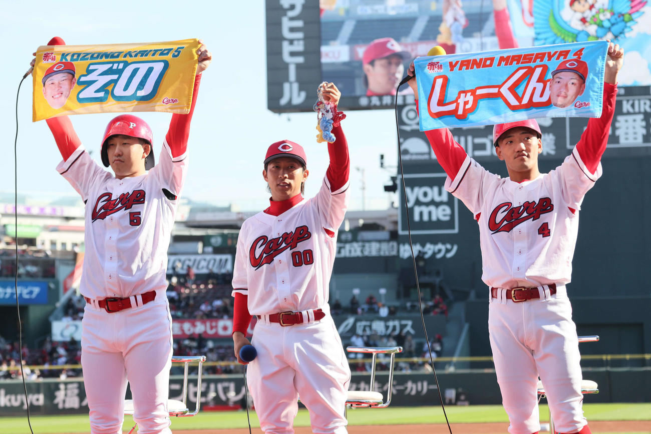 新グッズを紹介する左から小園、羽月、矢野（撮影・加藤孝規）　