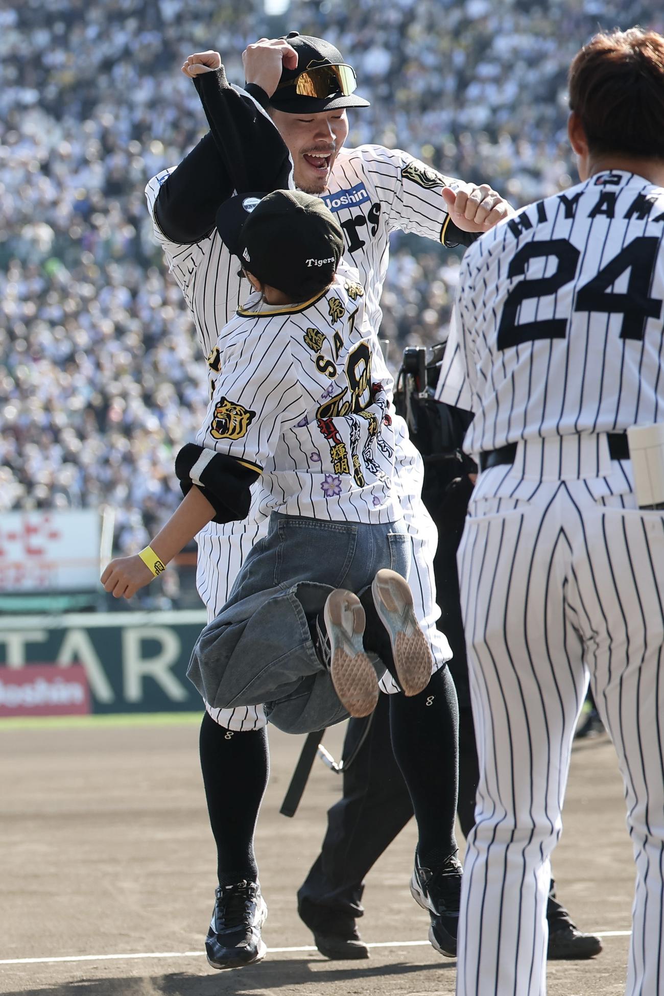 ファンの少女の夢を叶えるハイタッチを交わす阪神佐藤輝（撮影・前田充）