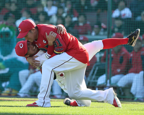 紅白戦ソフトボール対決　1回裏白組無死一塁、死球を出した坂倉（上）は羽月を投げ飛ばす（撮影・加藤孝規）　
