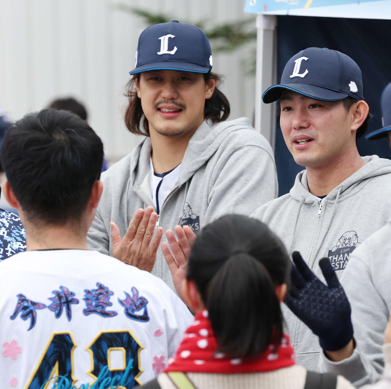 西武ファン感謝イベント「LIONS THANKS FESTA 2025」でファンとタッチを交わす西武高橋（左）と今井（撮影・宮地輝）