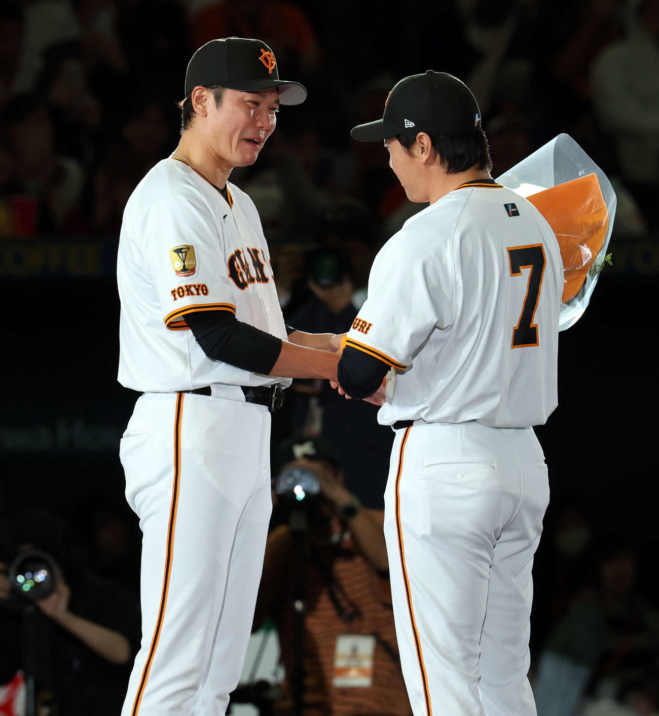 引退セレモニーで、大泣きする巨人坂本（左）から花束を贈られる長野（撮影・浅見桂子）
