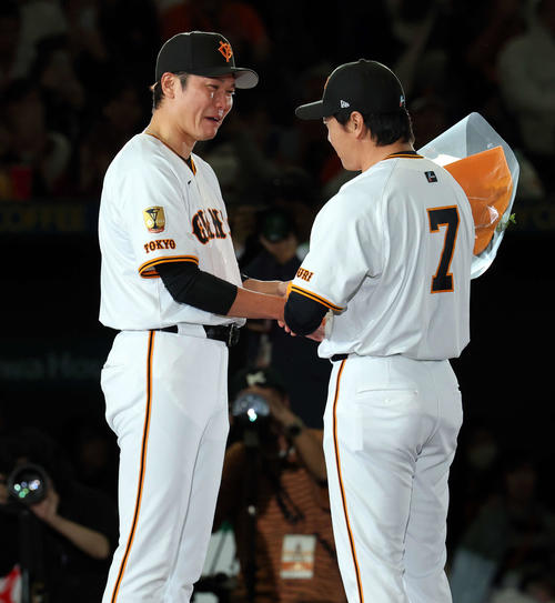 引退セレモニーで、大泣きする巨人坂本（左）から花束を贈られる長野（撮影・浅見桂子）
