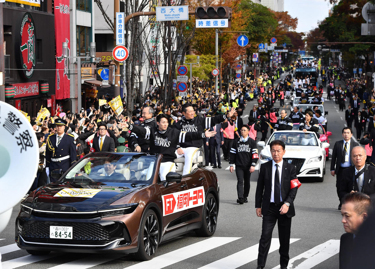 ソフトバンクの優勝祝賀パレードがスタートし、先頭車でファンに手を振る、左から孫オーナー、周東、小久保監督（撮影・岩下翔太）