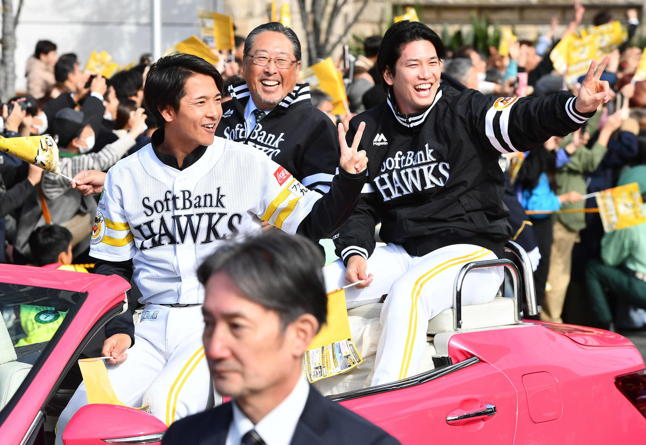 ソフトバンクの優勝祝賀パレードでピースサインを見せる柳町（左）と栗原（右）。中央は後藤球団社長（撮影・岩下翔太）