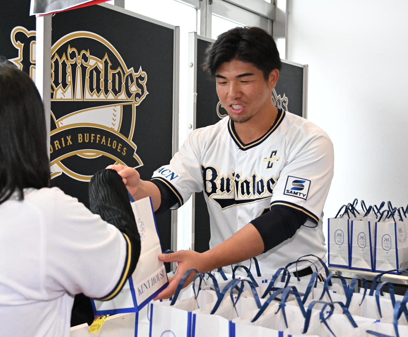 来場者にプリンを手渡す頓宮（撮影・石井愛子）