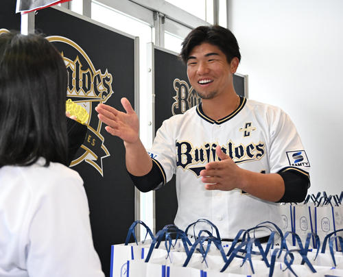 来場者にプリンを手渡しほいさーをする頓宮（撮影・石井愛子）
