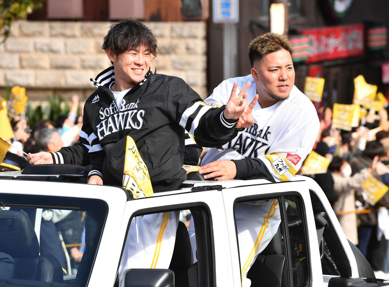 ソフトバンクの優勝祝賀パレードでピースサインを見せる牧原大（左）と山川（撮影・岩下翔太）