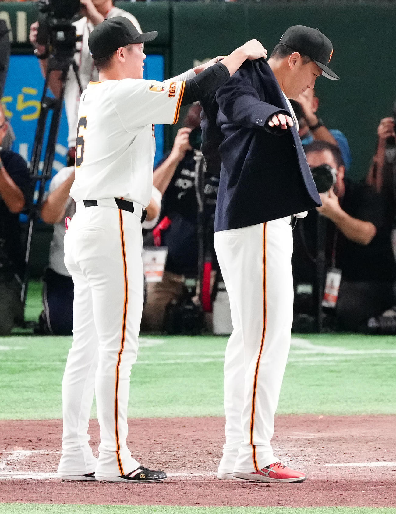 2025年10月1日、日米通算200勝セレモニーで、坂本（左）から名球会ブレザーを着せてもらう巨人田中将（撮影・鈴木みどり）