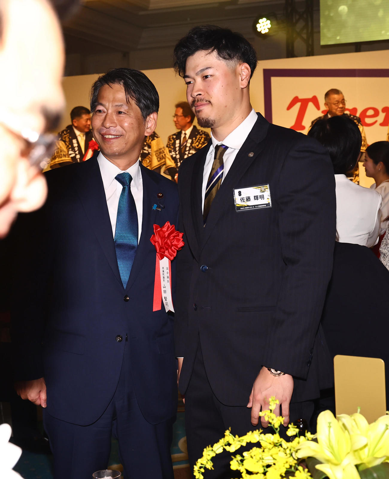 佐藤輝（右）は衆議院議員・山田氏と記念撮影をする（撮影・上田博志）
