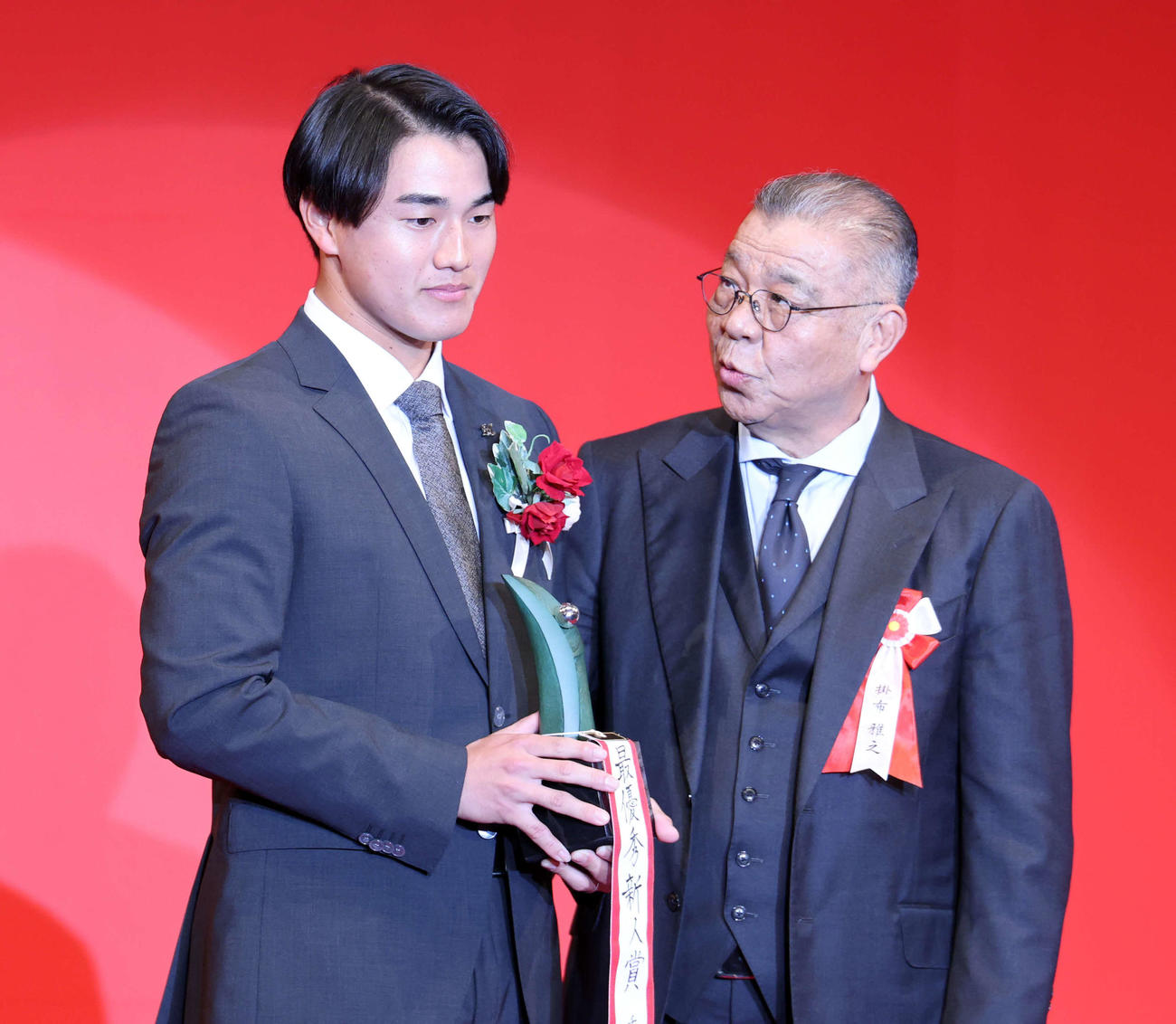NPB AWARDS 2025　パ・リーグ最優秀新人賞を受賞したロッテ西川（左）はプレゼンターの掛布雅之氏から声をかけられる（撮影・浅見桂子）