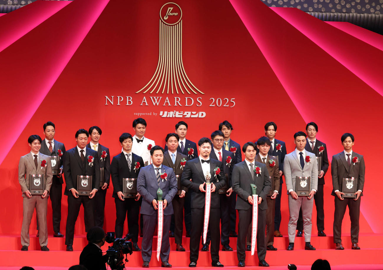 NPB AWARDS 2025　最優秀選手賞を受賞した阪神佐藤輝（中央）、最優秀新人賞のヤクルト荘司（同左）、ロッテ西川（同右）を囲み記念撮影する受賞者たち（撮影・浅見桂子）