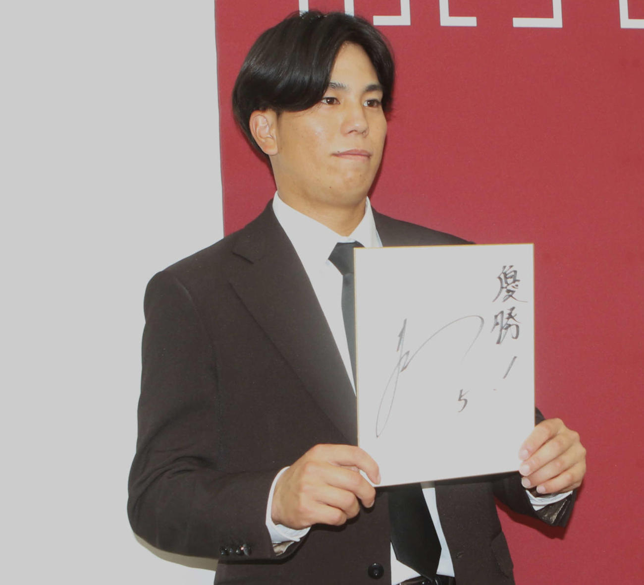 契約更改を終えて「優勝」を書かれた色紙を持つ門脇
