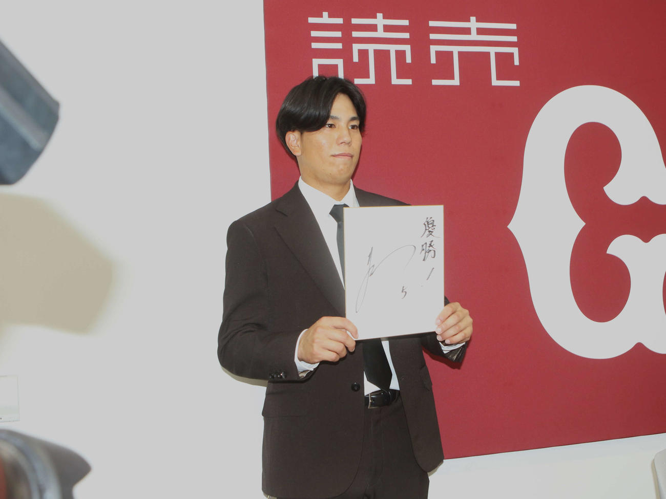 契約更改を終えて「優勝」を書かれた色紙を持つ門脇