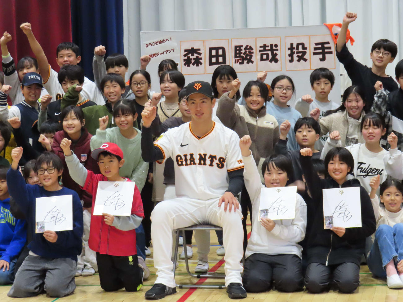 小学生と記念写真に納まる巨人森田（撮影・水谷京裕）