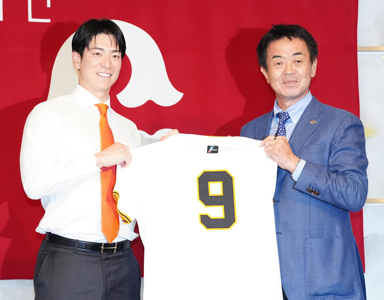 巨人入団会見に臨み、水野編成本部長（右）と背番号「9」のユニホームを手にする松本（撮影・江口和貴）