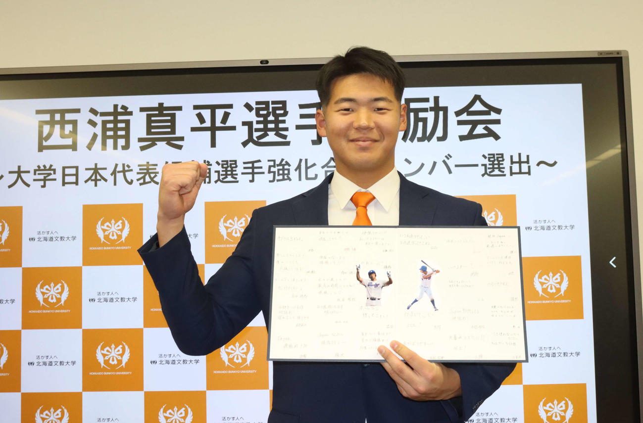 大学日本代表候補合宿に参加する北海道文教大の西浦はチームメートから寄せ書きを受け取りガッツポーズ（撮影・保坂果那）