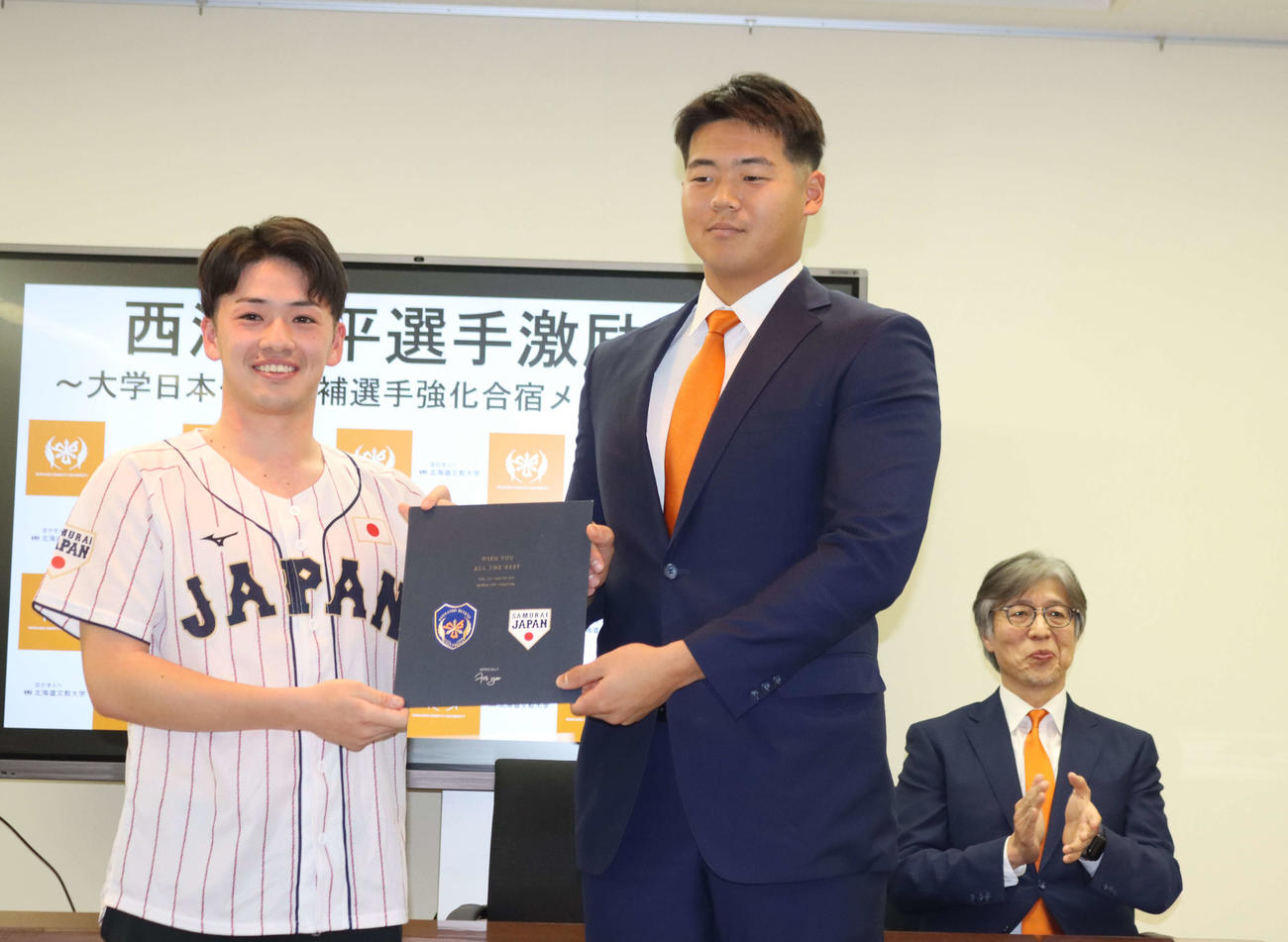 大学日本代表候補合宿に参加する北海道文教大の西浦（右）はチームメートからの寄せ書きを受け取る（撮影・保坂果那）