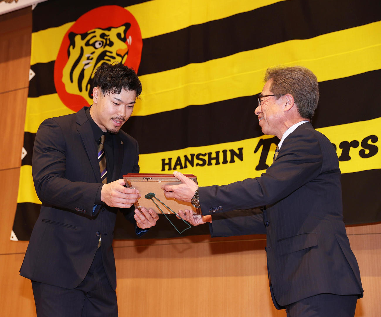若林忠志賞を受賞し粟井社長（右）から盾を受け取る佐藤輝（撮影・上山淳一）