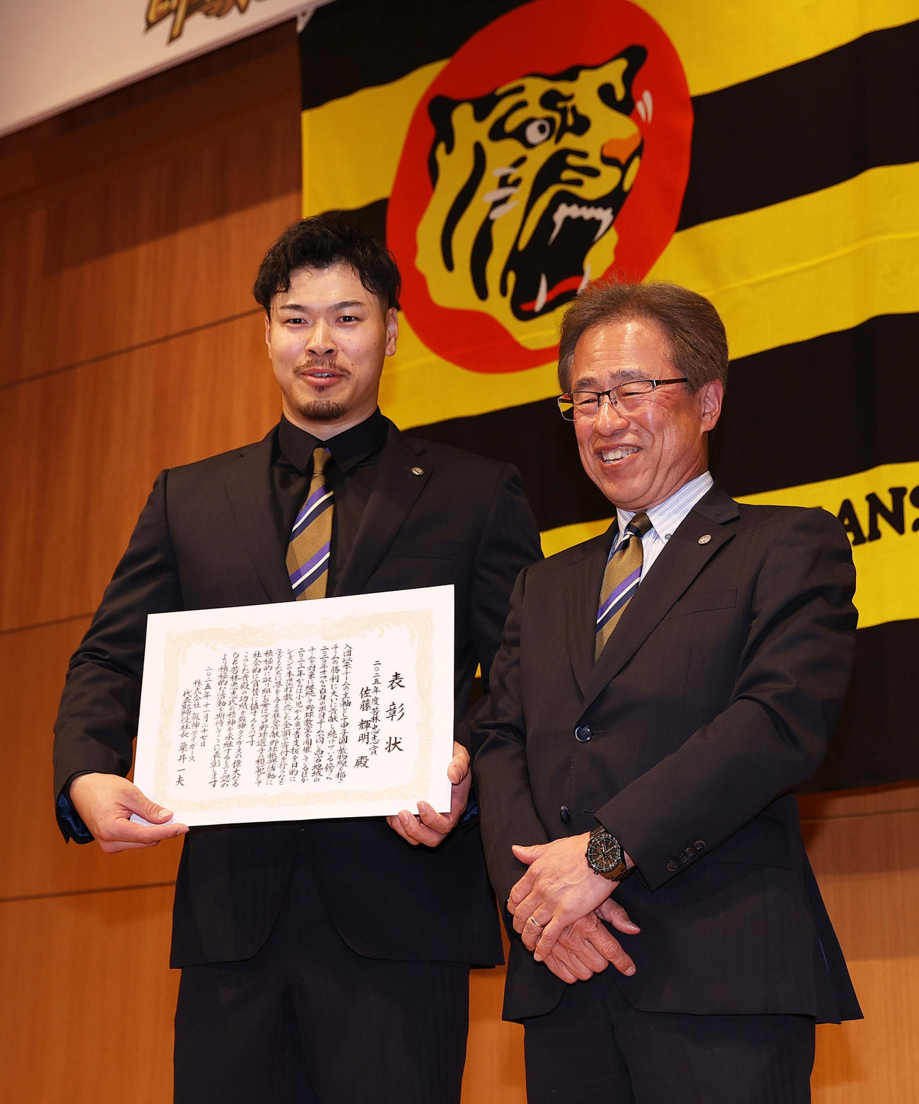 若林忠志賞を受賞した佐藤輝（左）は粟井社長から賞状を受け取り笑顔を見せる（撮影・上山淳一）