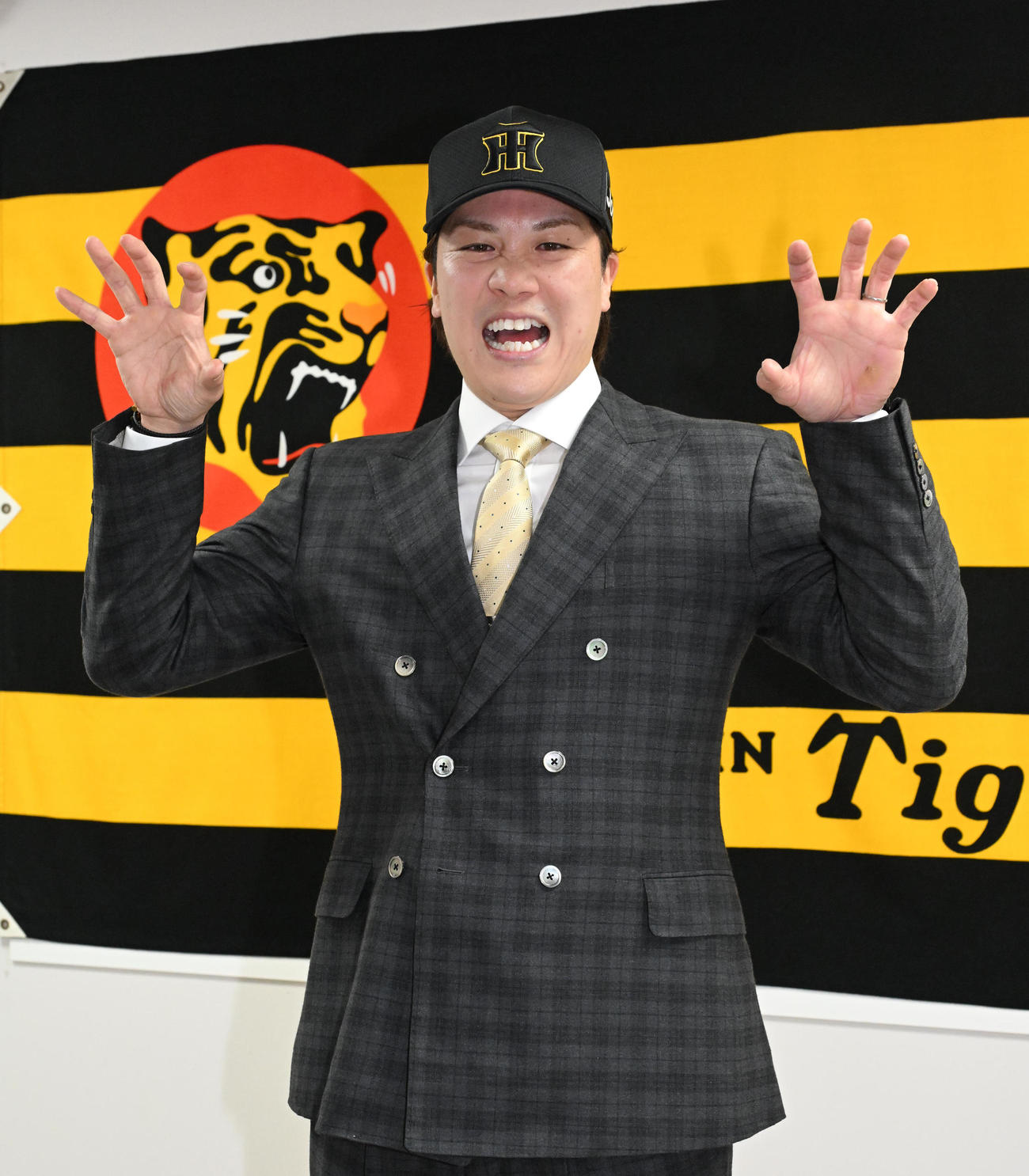 入団会見に臨み、虎ポーズをする伏見（撮影・石井愛子）