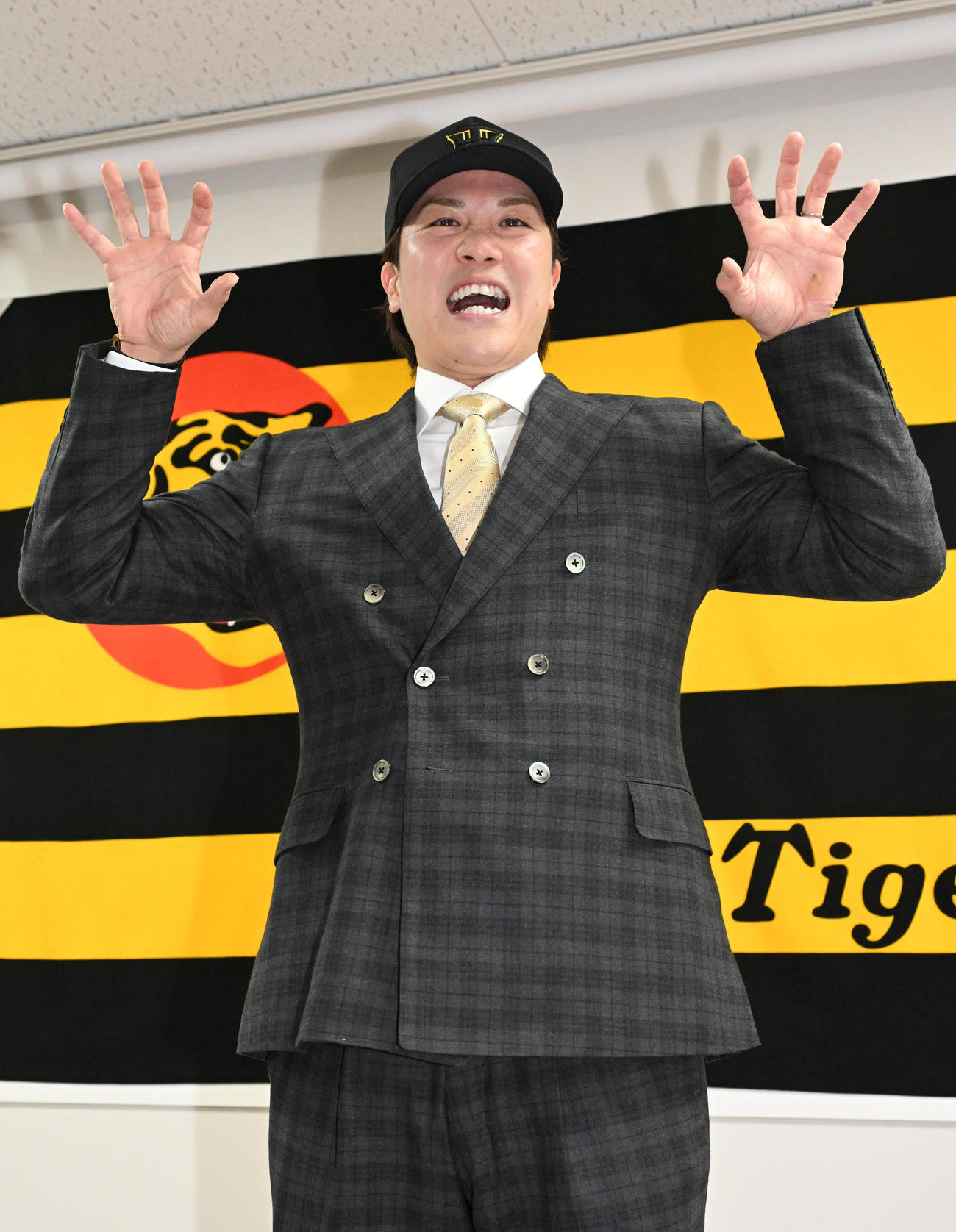 入団会見に臨み、虎ポーズをする伏見（撮影・石井愛子）