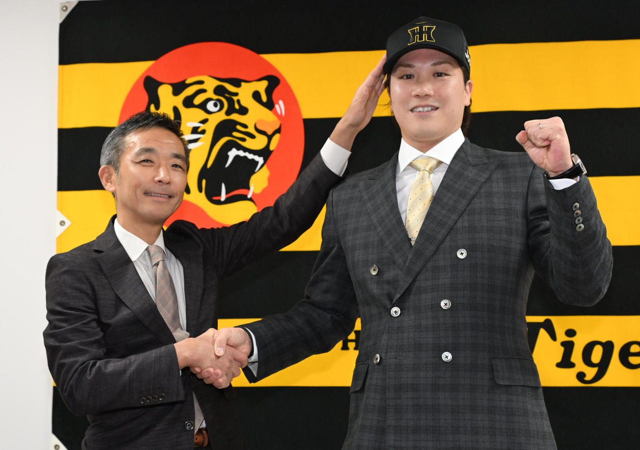 フォトセッションに応じる阪神竹村孝行球団本部副本部長（左）、伏見（撮影・石井愛子）