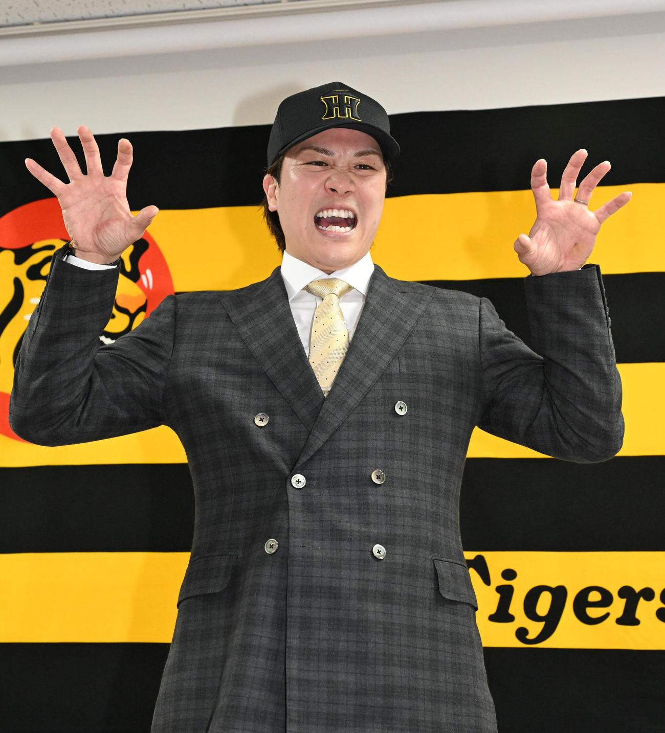 入団会見に臨み、虎ポーズをする伏見（撮影・石井愛子）