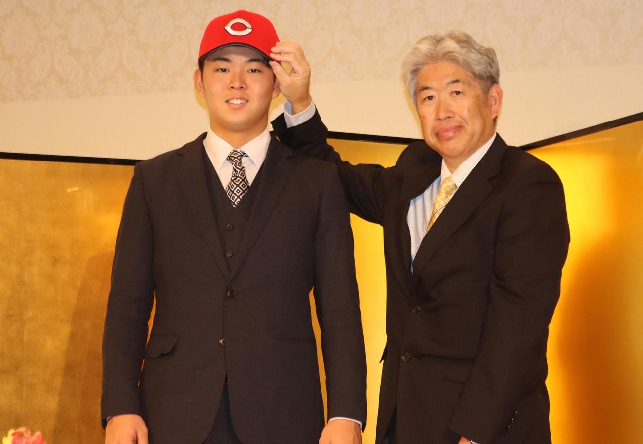 仮契約に臨んだ広島ドラフト1位の仙台大・平川（左）と近藤スカウト（撮影・保坂果那）