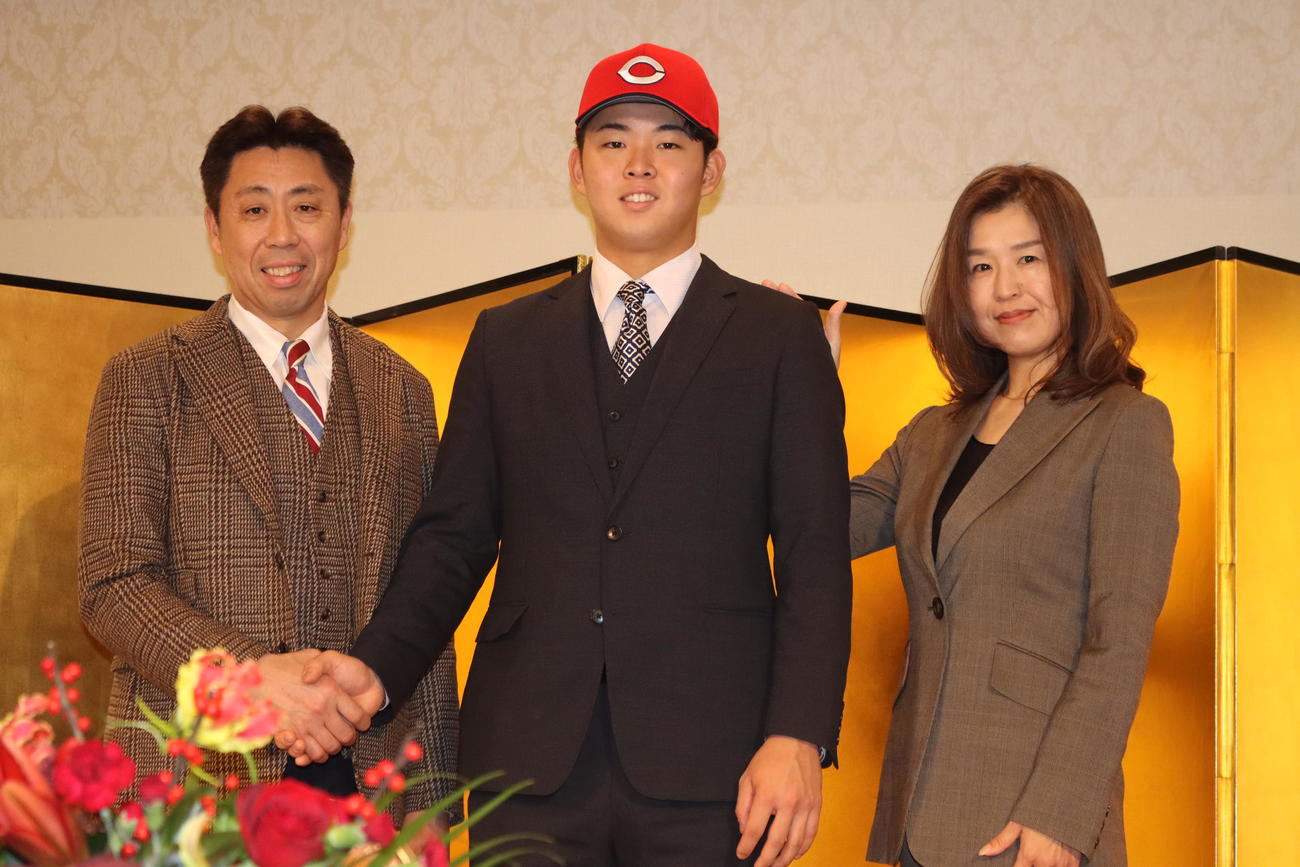 仮契約に臨んだ広島ドラフト1位の仙台大・平川（中央）。左は父敦さん、右は母陽子さん（撮影・保坂果那）