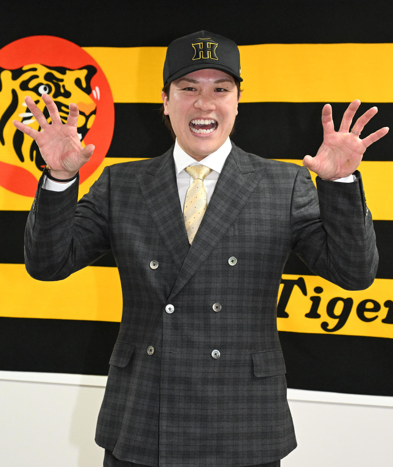 入団会見に臨み、虎ポーズをする伏見（撮影・石井愛子）