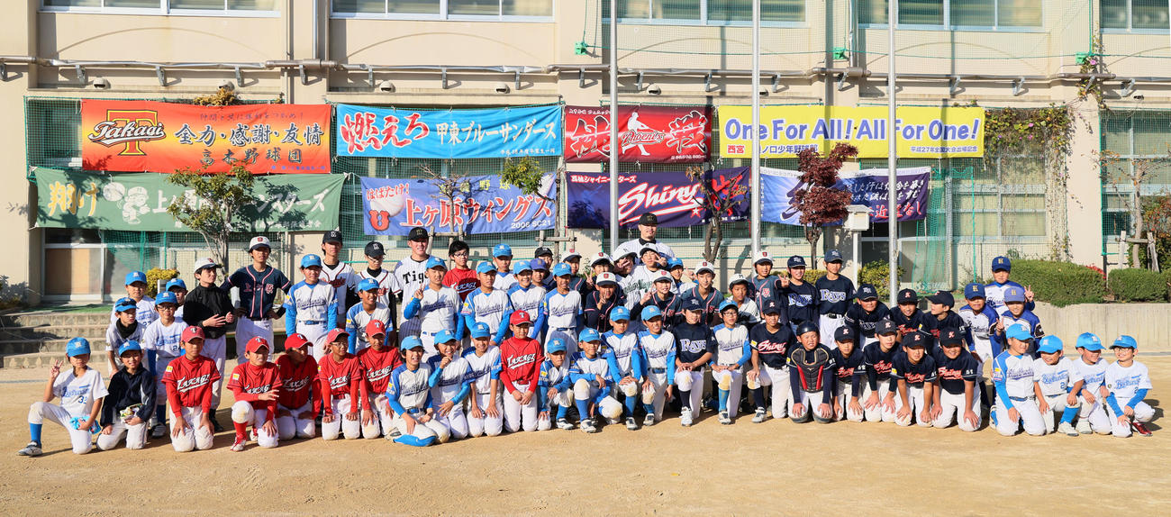 「佐藤輝明後援会」が主催する野球教室に参加した子どもたちと記念写真に納まる富田（左）と佐藤輝（撮影・加藤哉）
