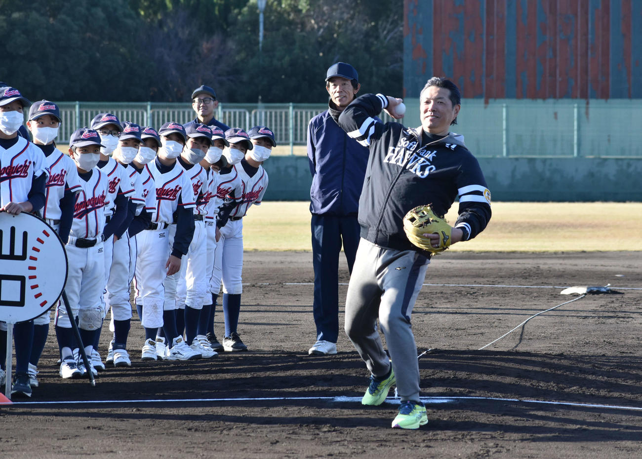 児童が見つめる中で始球式を行う小久保監督（撮影・只松憲）