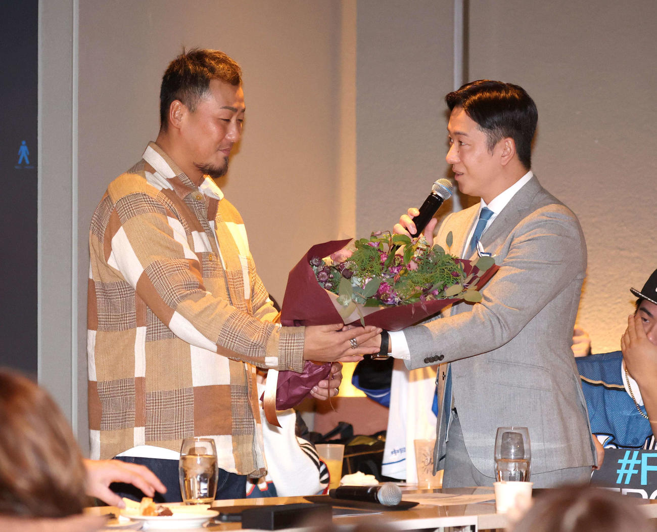 トークショーで中田氏（左）に花束を渡す斎藤氏（撮影・黒川智章）