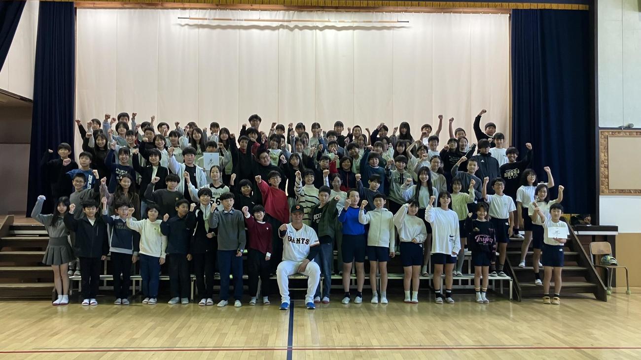 記念撮影に臨む小学生と巨人又木（撮影・北村健龍）