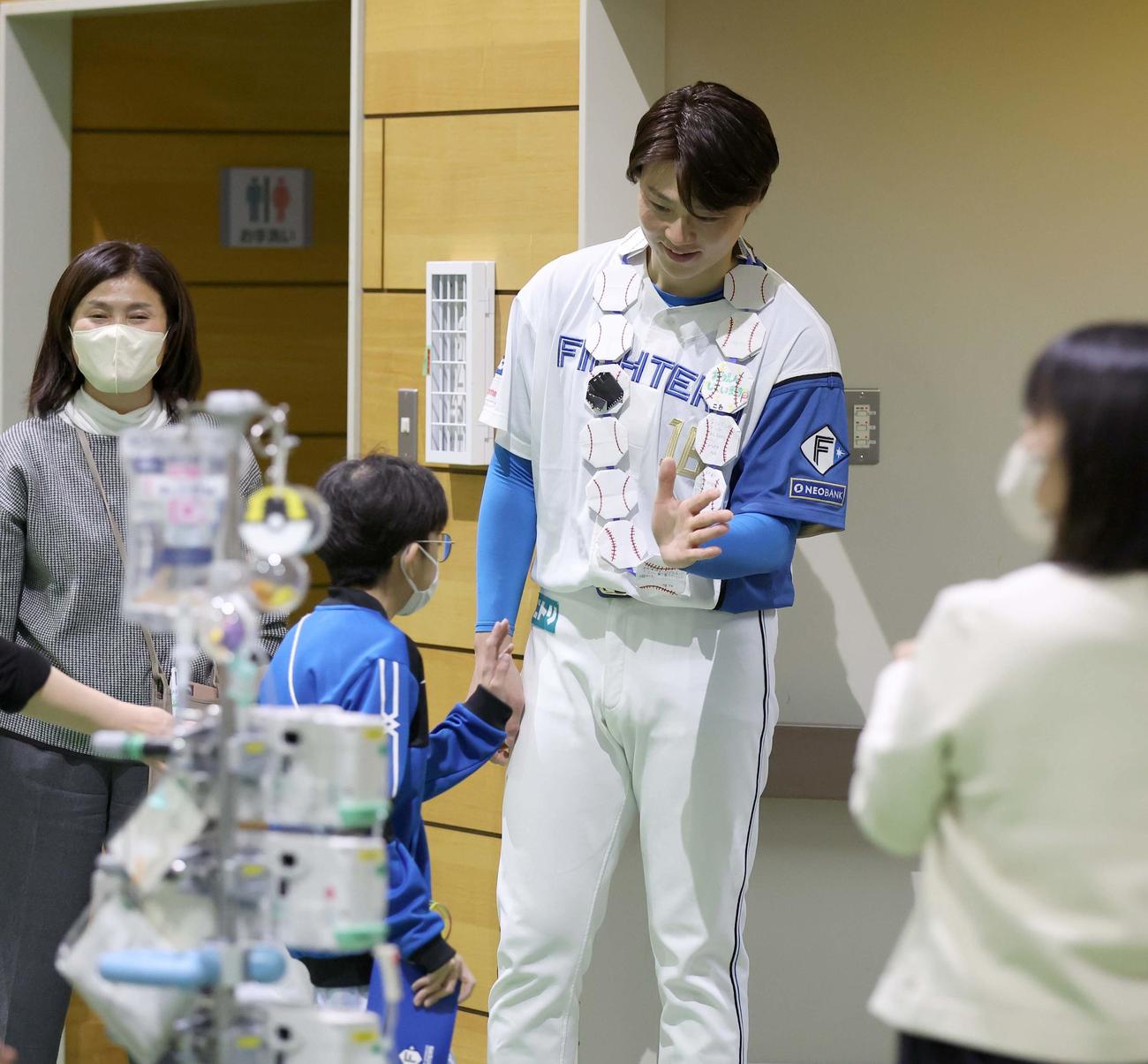 北海道大学病院小児科を訪問し子どもたちとハイタッチする日本ハム山崎（撮影・黒川智章）
