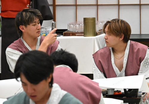 選手会納会で宮城（右）の写真を撮るオリックス紅林（撮影・石井愛子）